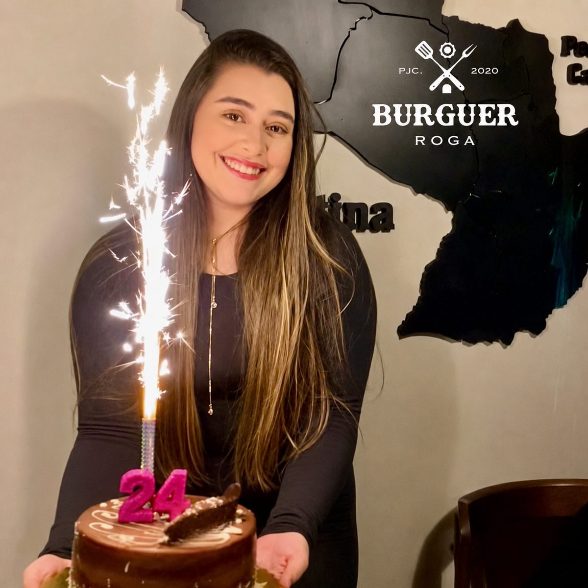 Cumpleañera con su torta y vela de bengala en Burguer Roga