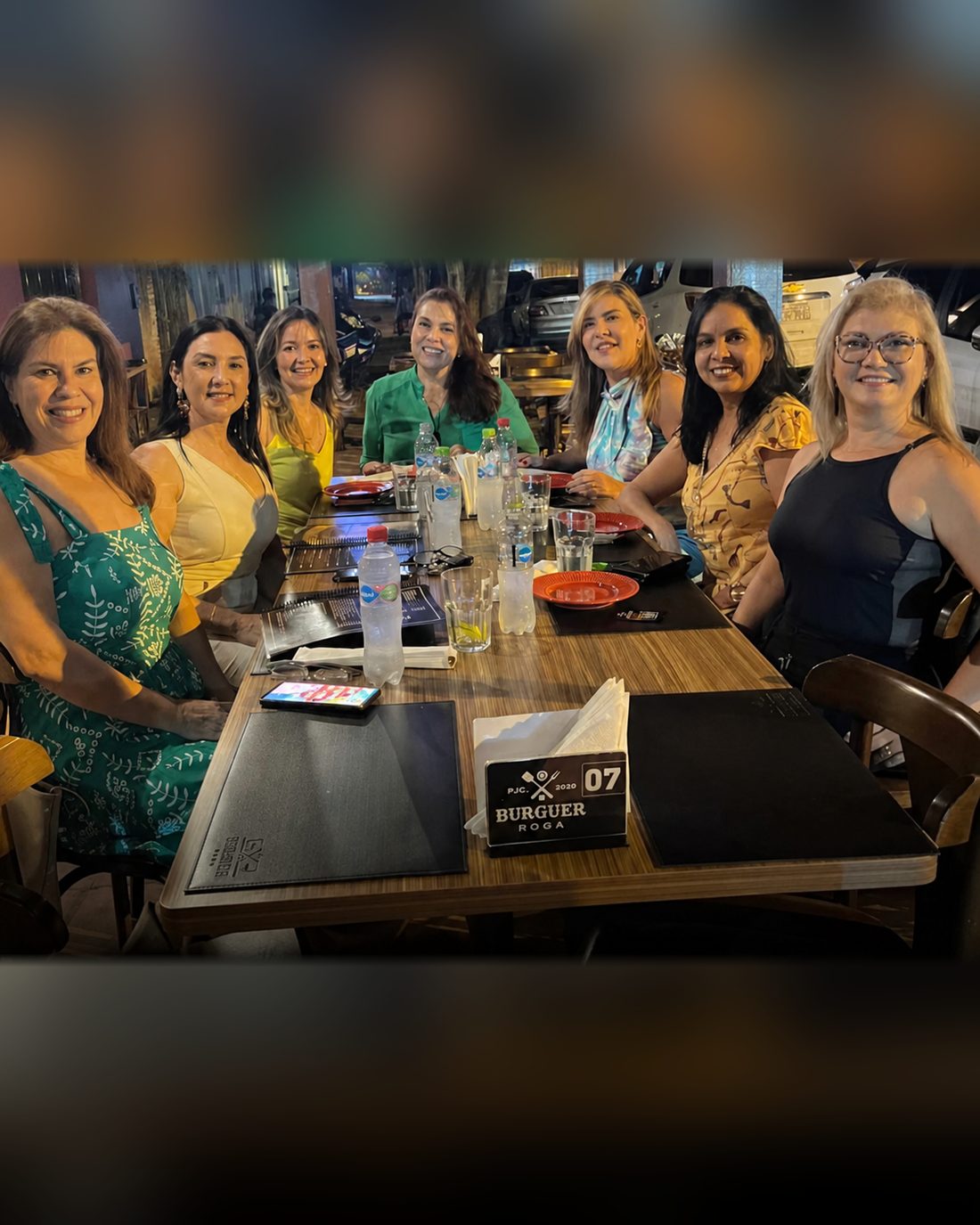 Grupo de amigas celebrando en su mesa de Burguer Roga
